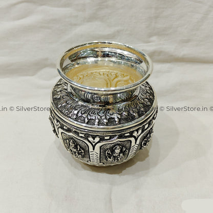 Decorative silver container with intricate designs on a white background